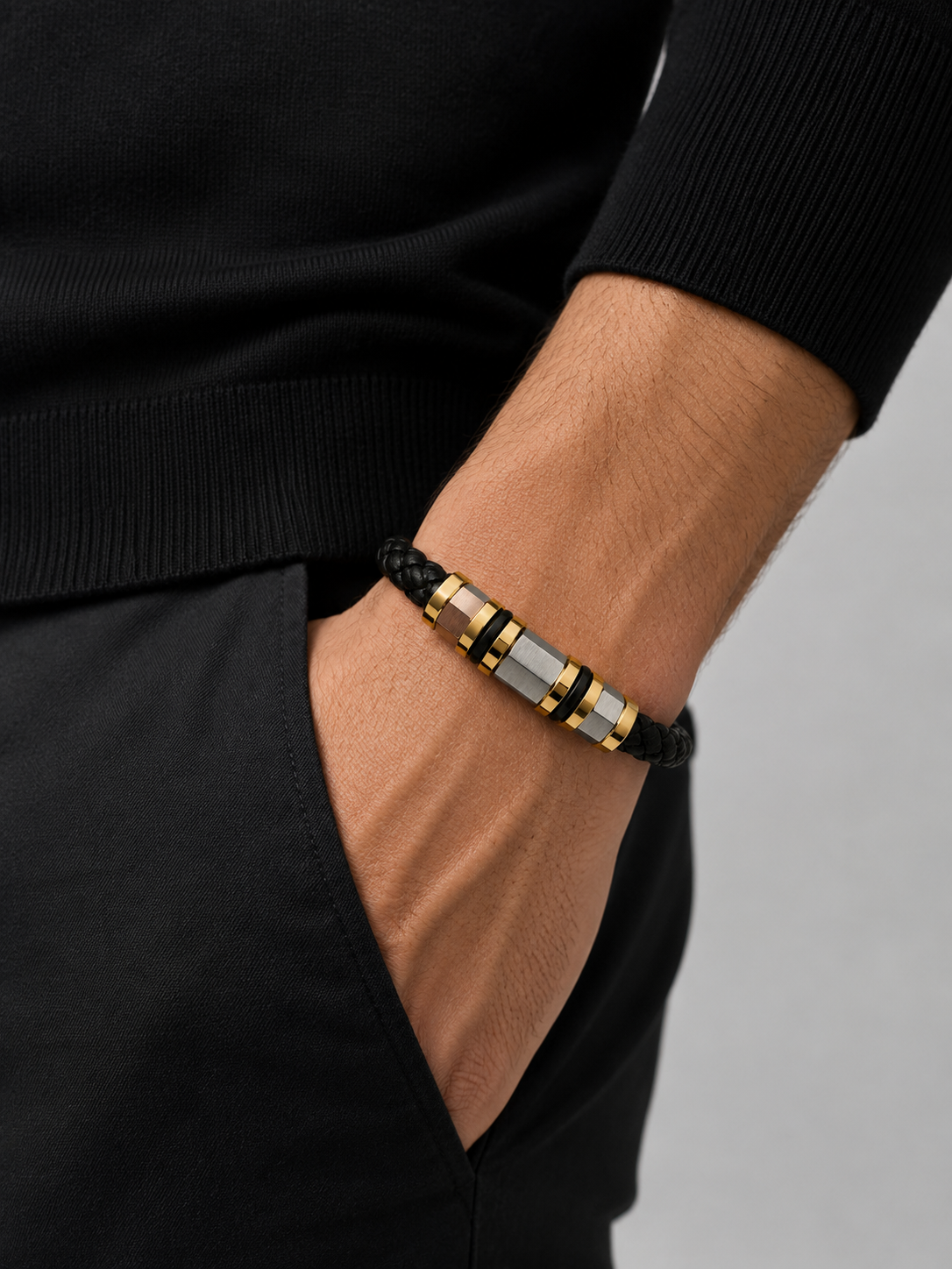 Man wearing the Barutti black braided leather bracelet with gold and steel accent on the wrist