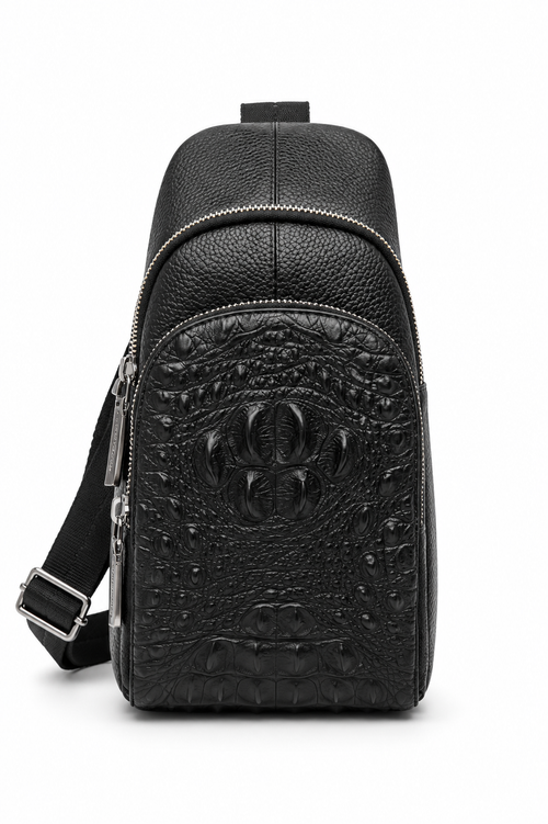 The Bergamo crocodile-embossed leather sling bag in black, worn across the chest