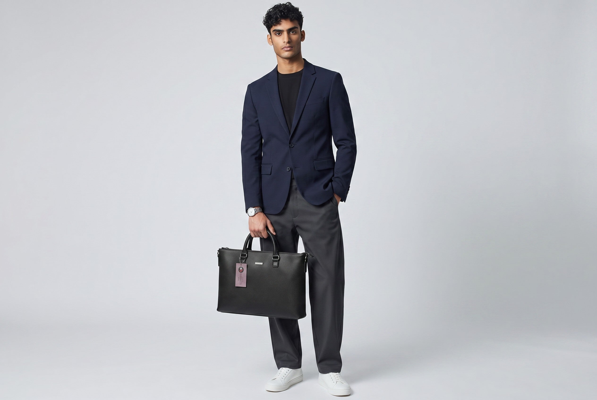 Man in a navy blazer holding a black Barutti Bags & Accessories Genova full-grain leather slim laptop briefcase.