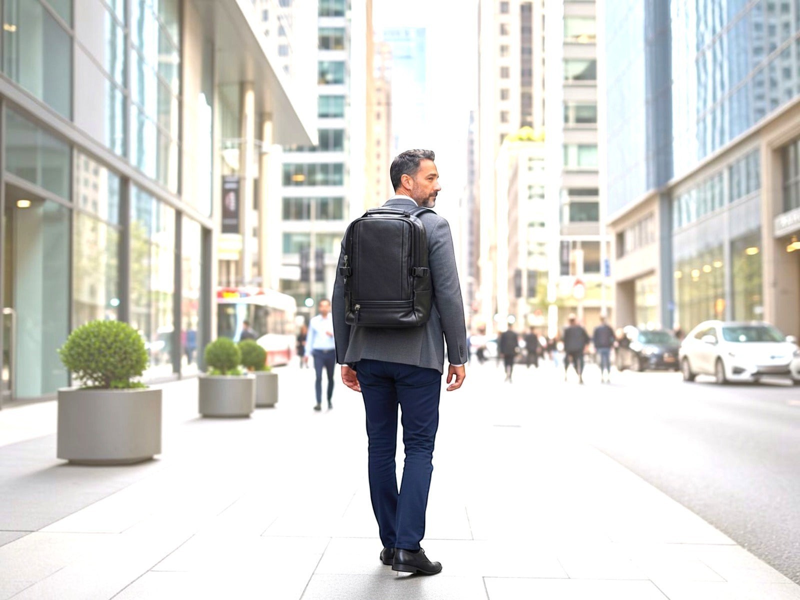 Man wearing a black Barutti Bags & Accessories Vicenza full-grain leather laptop backpack in a city business district.